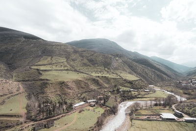 White clouds of green and brown mountains during the day
